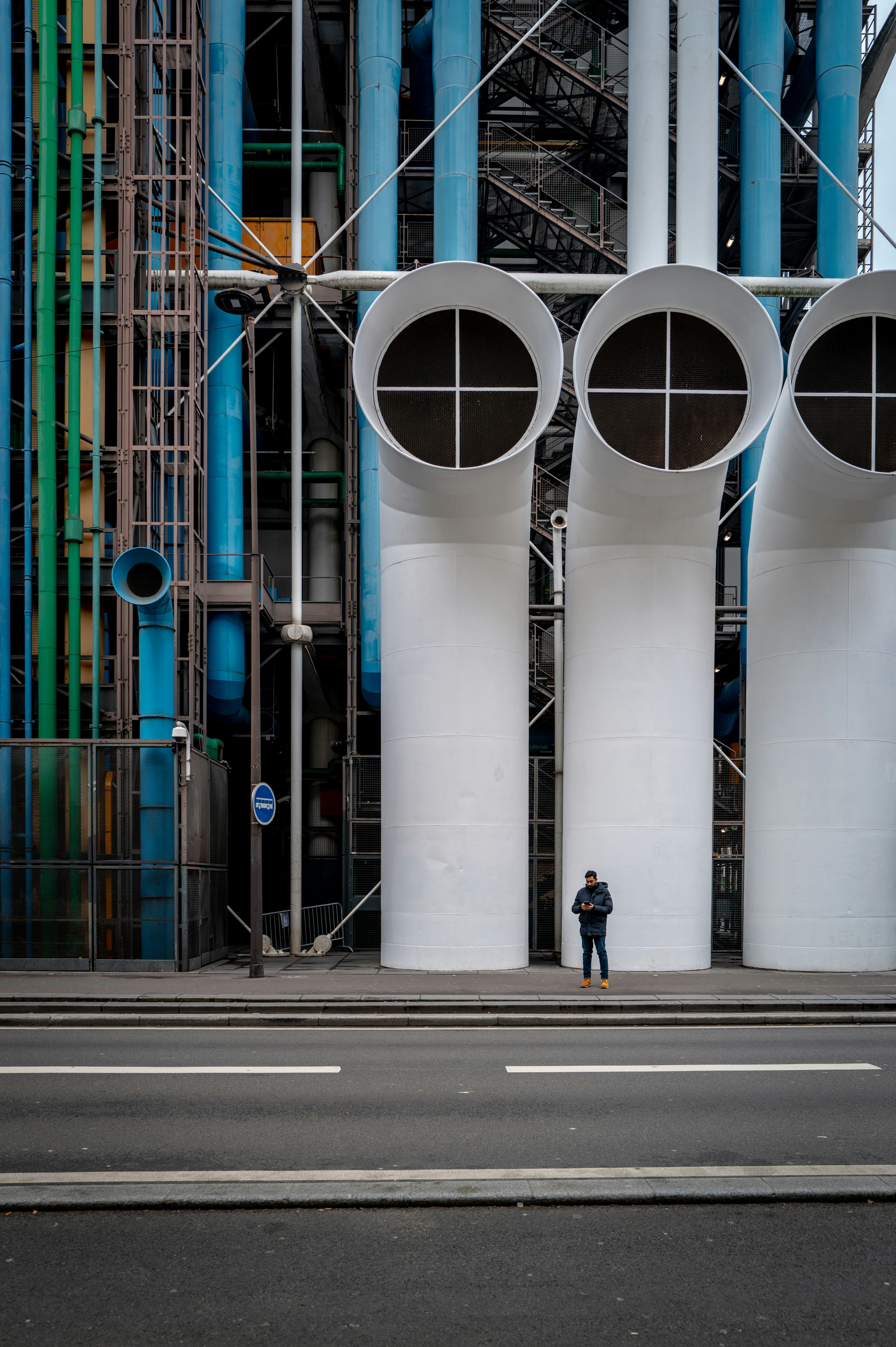 Un homme debout devant trois grands tuyaux