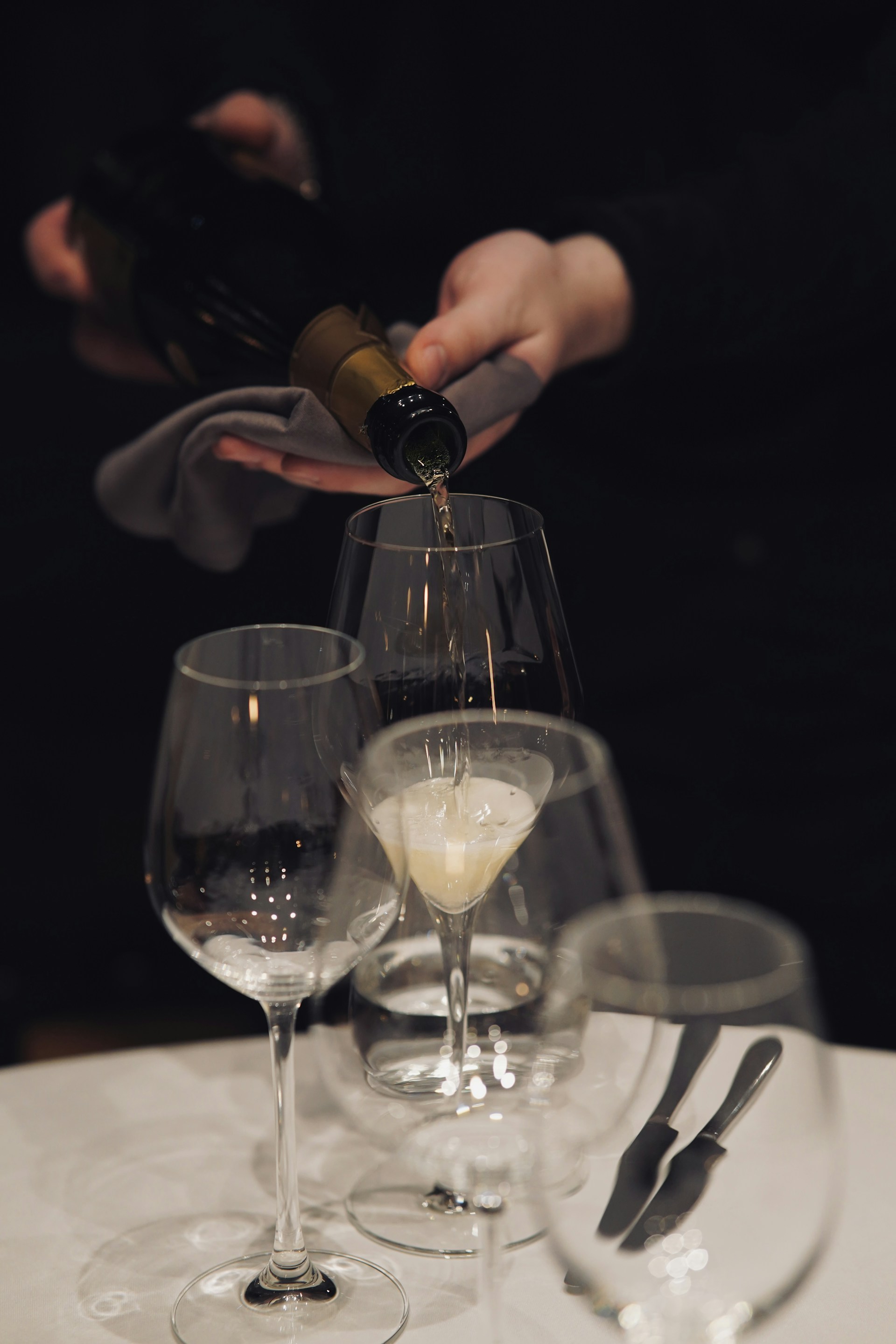 A person pouring wine into a wine glass