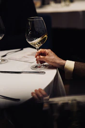 A couple of people sitting at a table with wine glasses