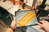 A person holding a tablet with a yellow object on it