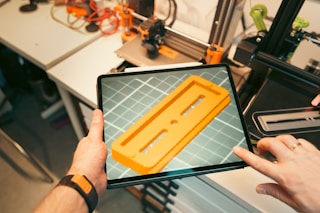 A person holding a tablet with a yellow object on it