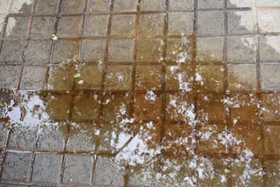 A puddle of water sitting on top of a tiled floor