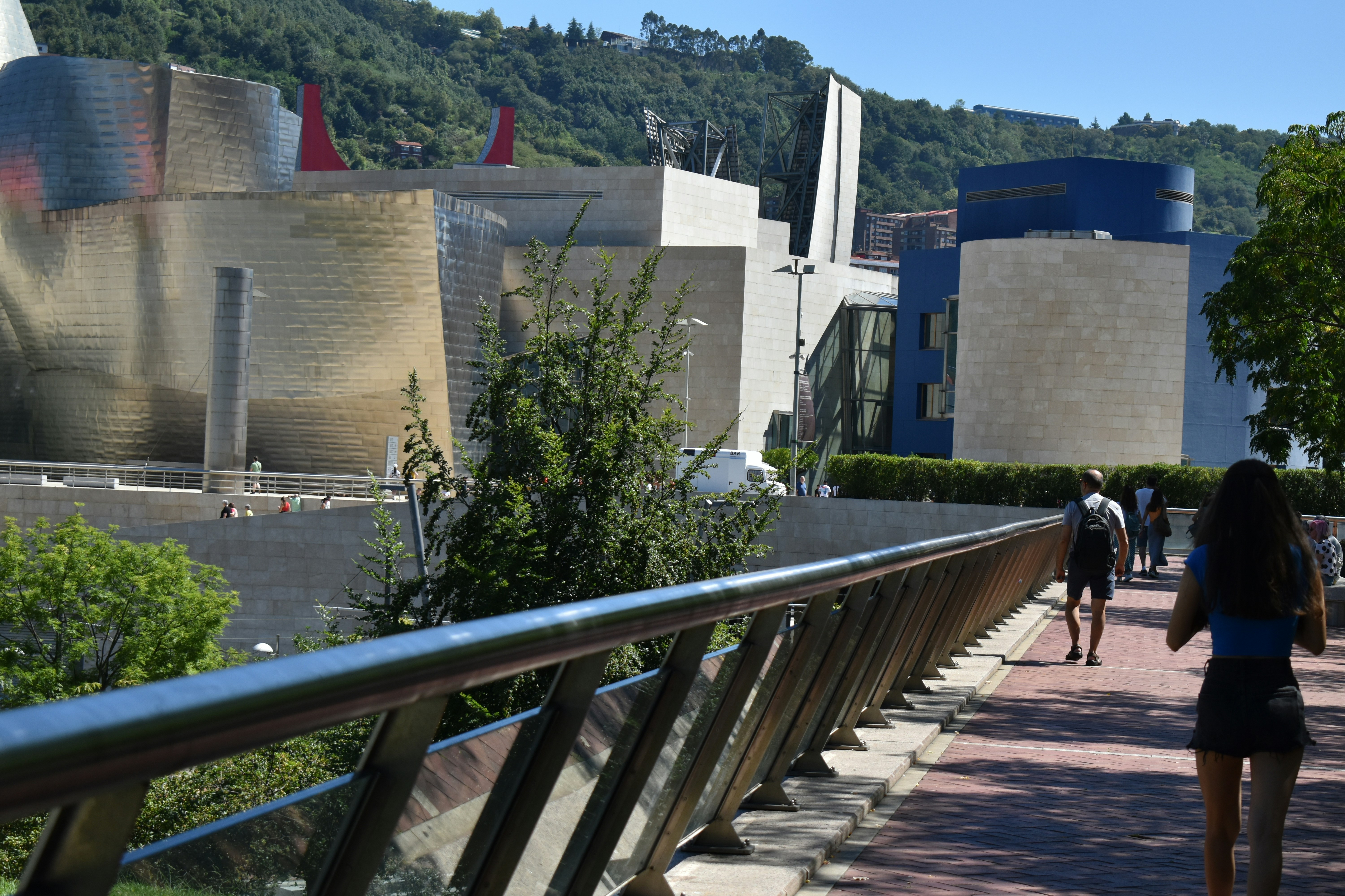 A group of people walking down a sidewalk next to a building photo ...