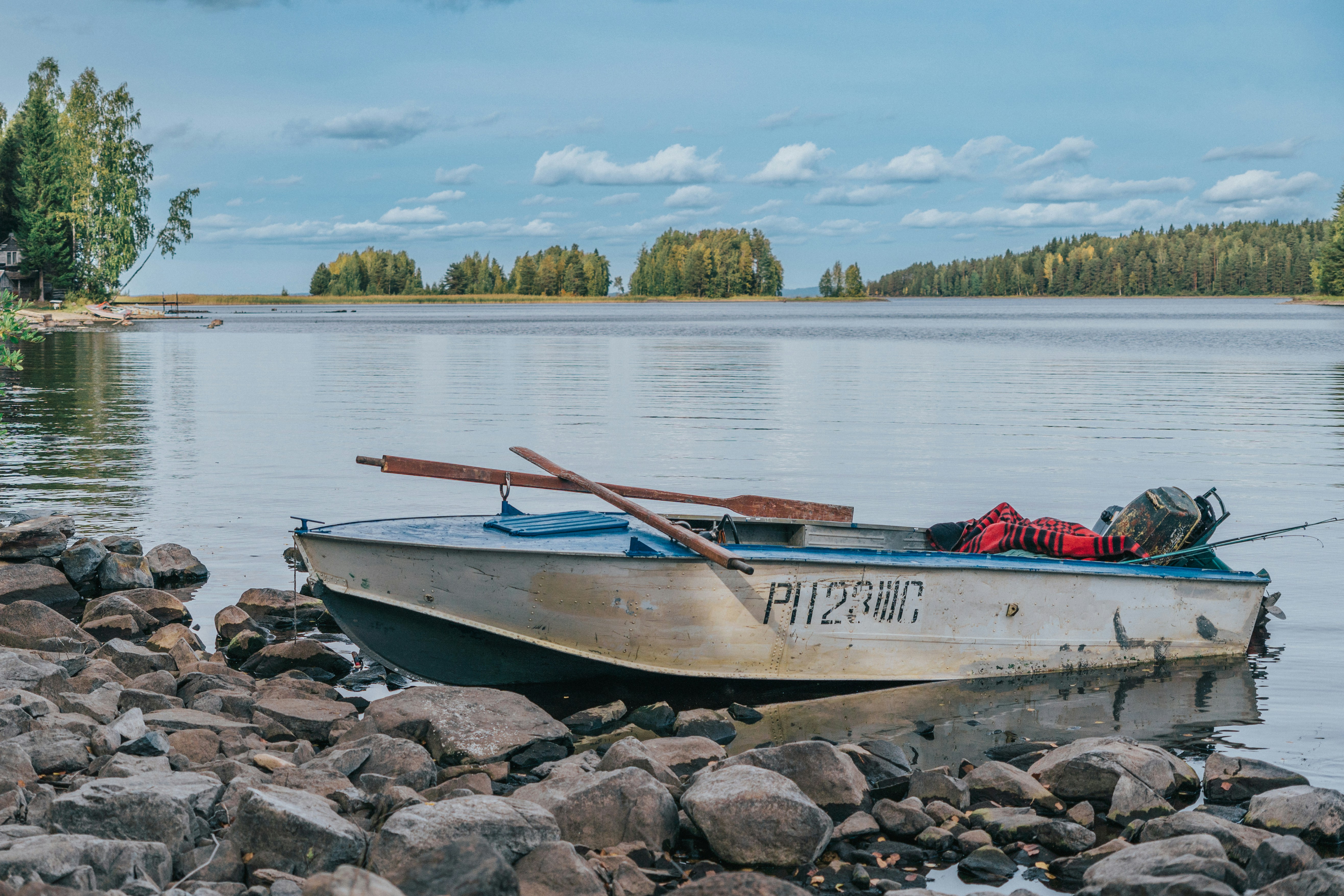 A small boat sitting on the shore of a lake