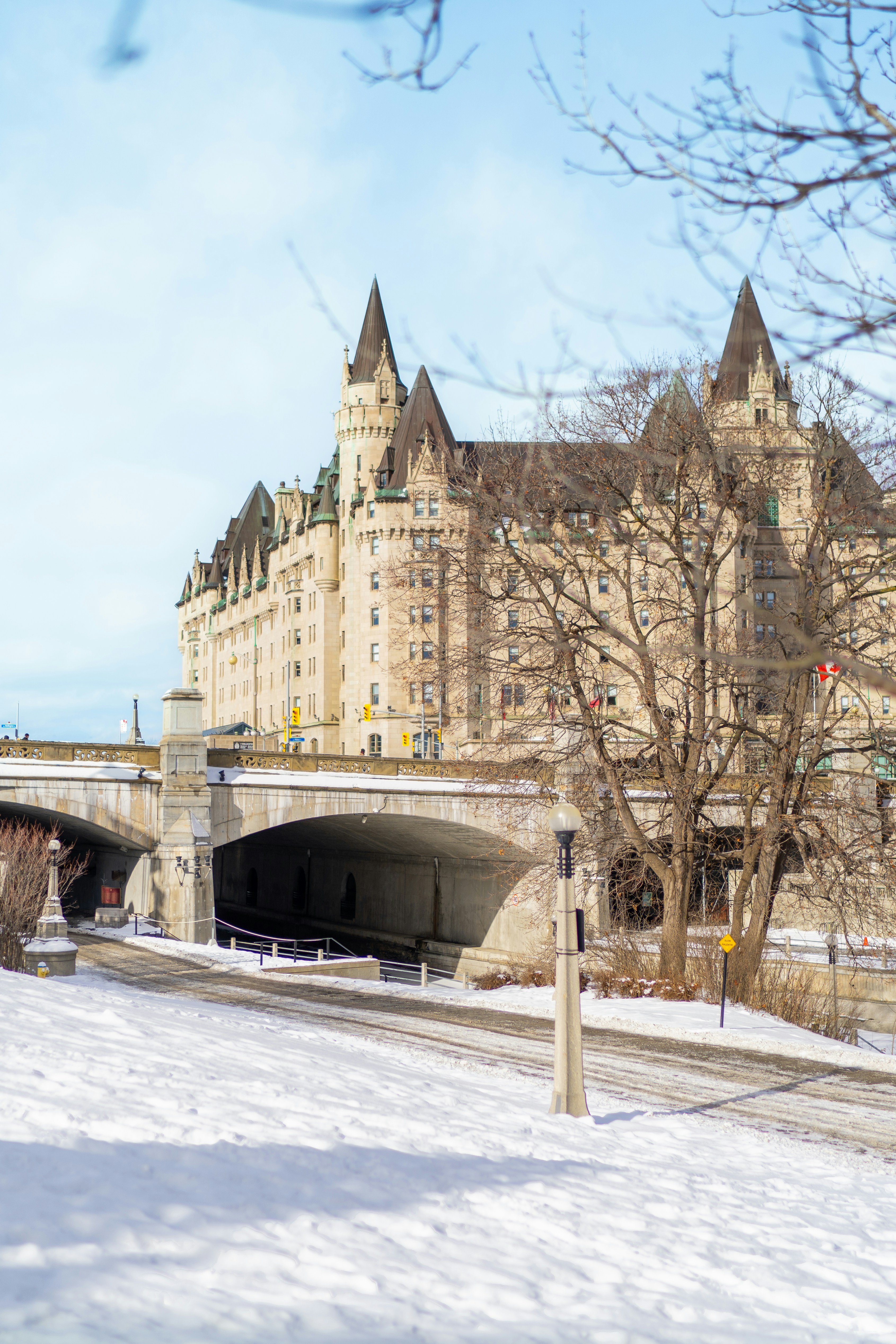 A snow covered street with a bridge in the background