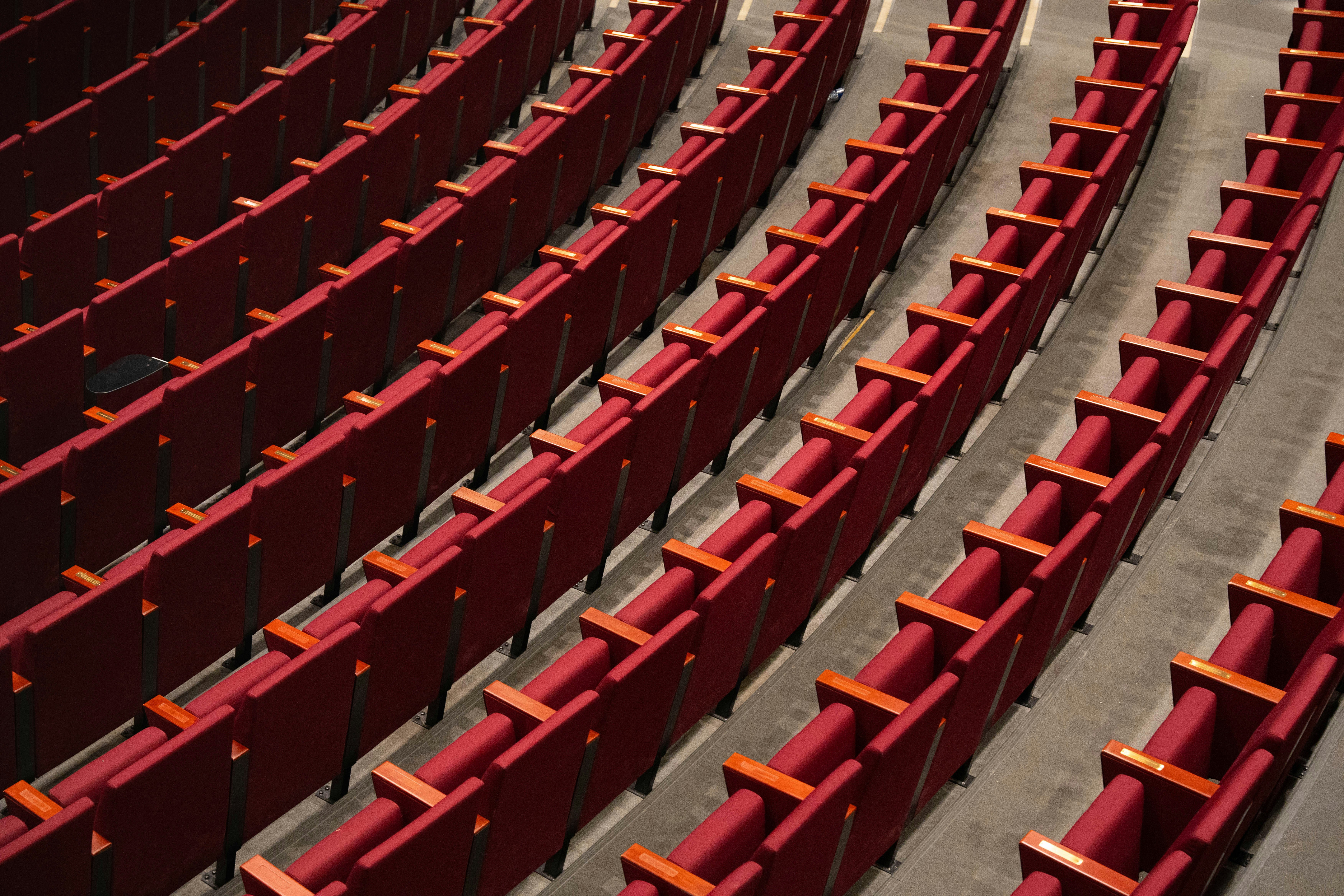 Rows of red seats in a large auditorium