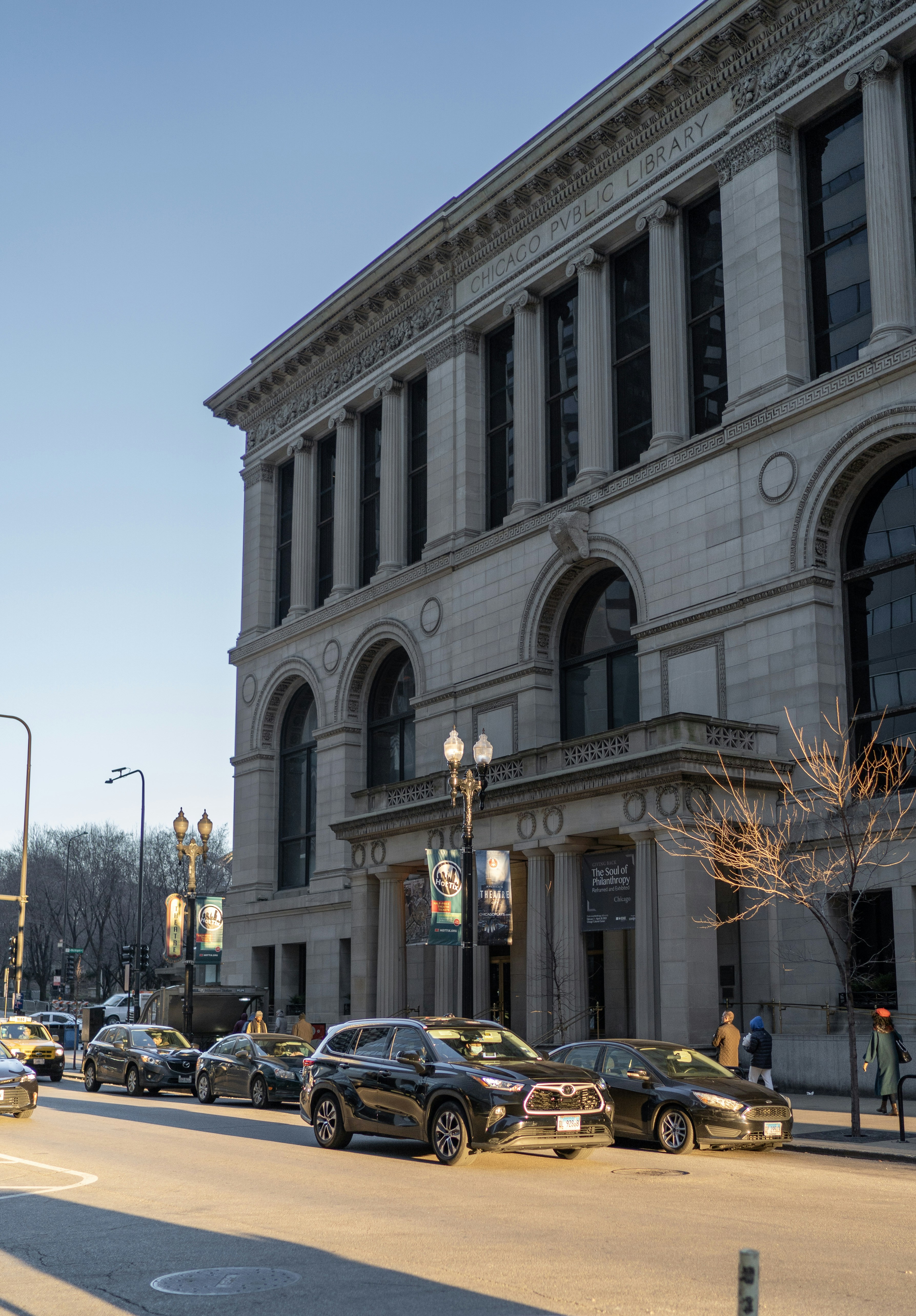 Una calle de la ciudad llena de mucho tráfico junto a un edificio alto