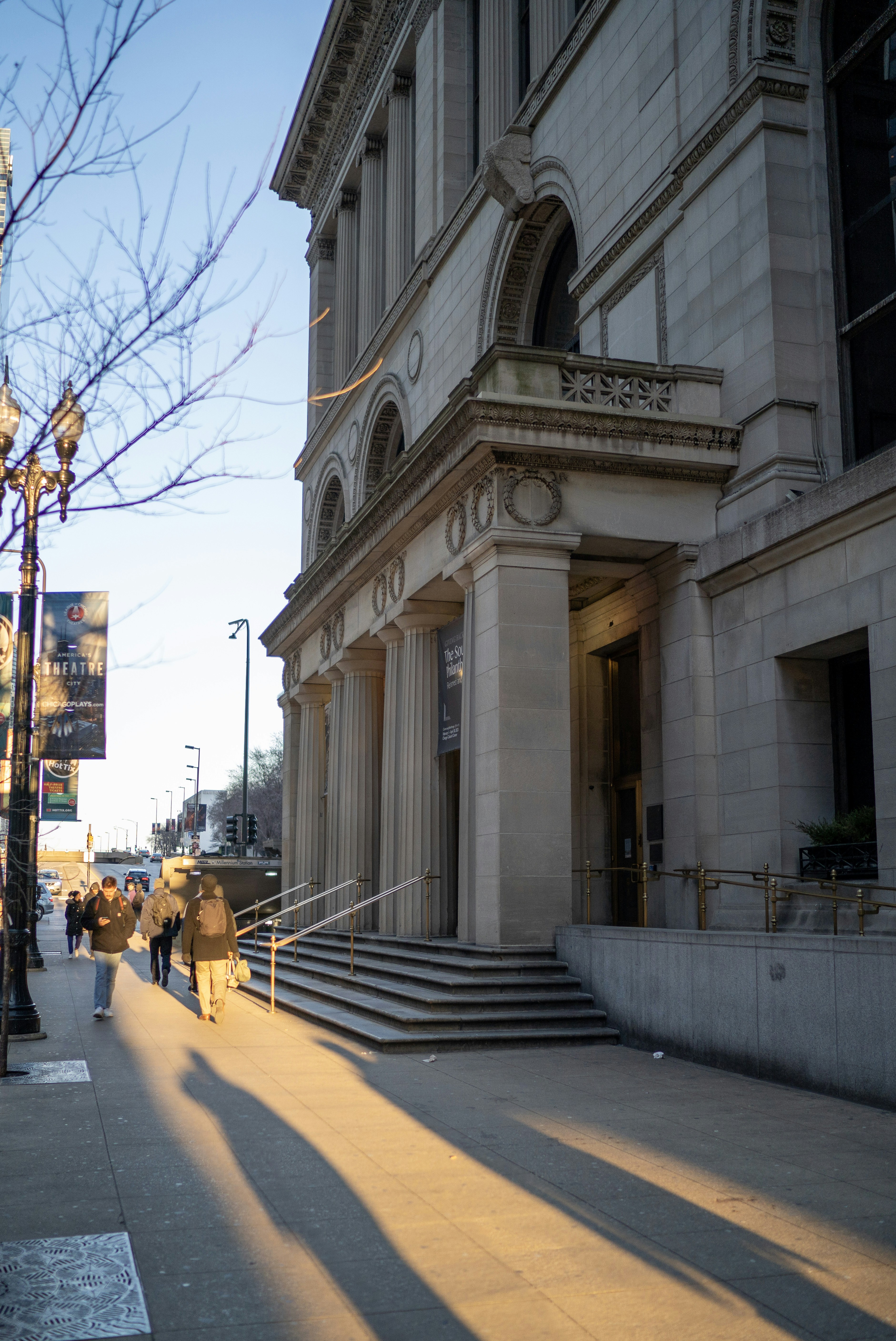 Una persona caminando por una calle junto a un edificio alto