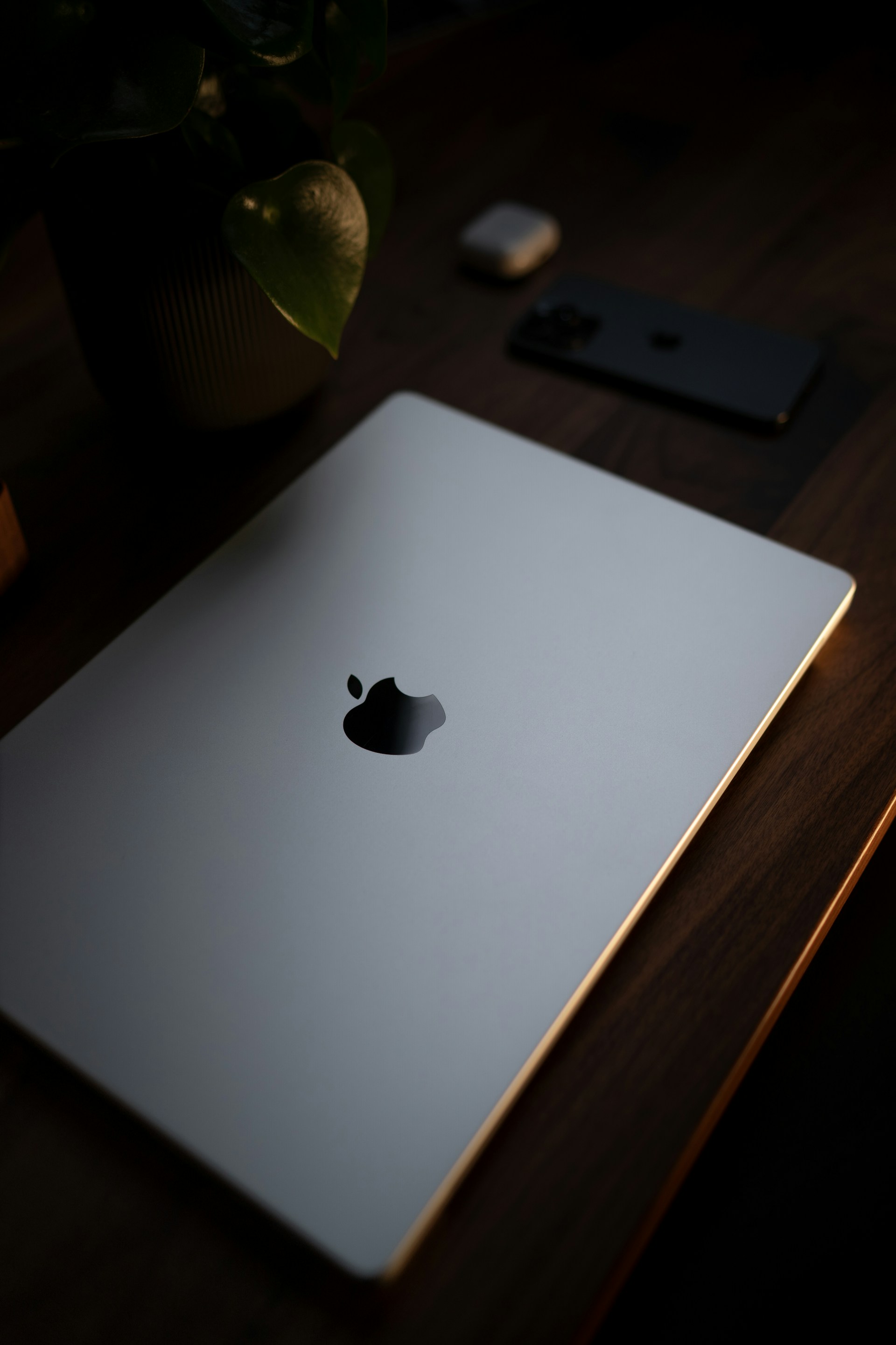 An apple laptop sitting on top of a wooden table