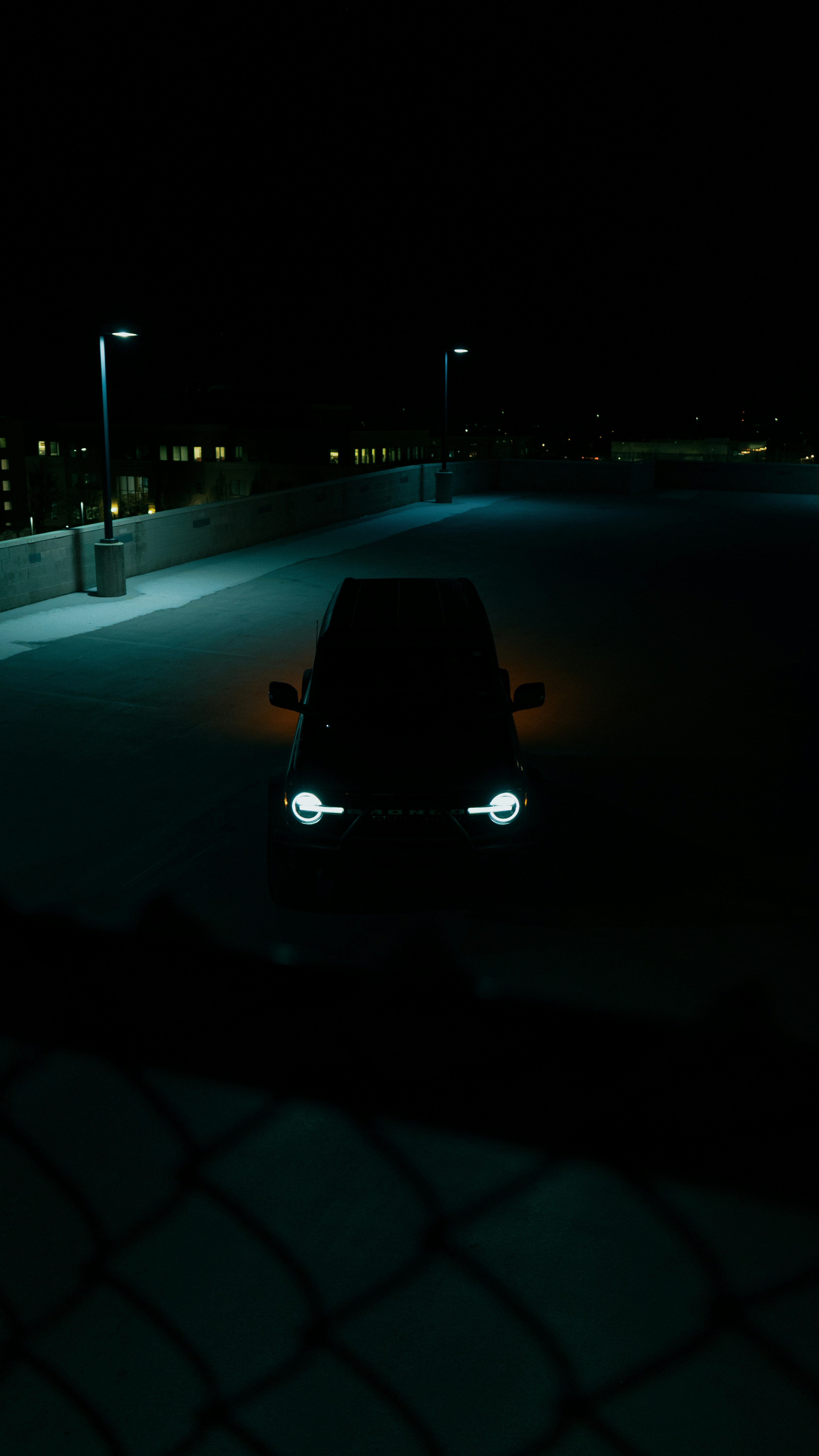 A car parked in a parking lot at night