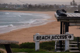 A beach access sign on the side of the beach