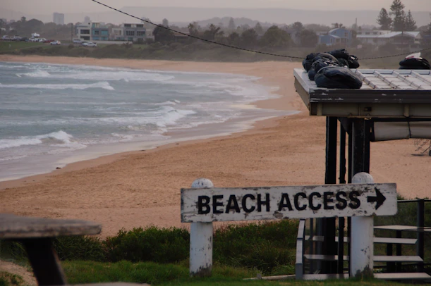 A beach access sign on the side of the beach