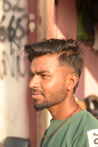 A man in a green shirt standing in front of a building