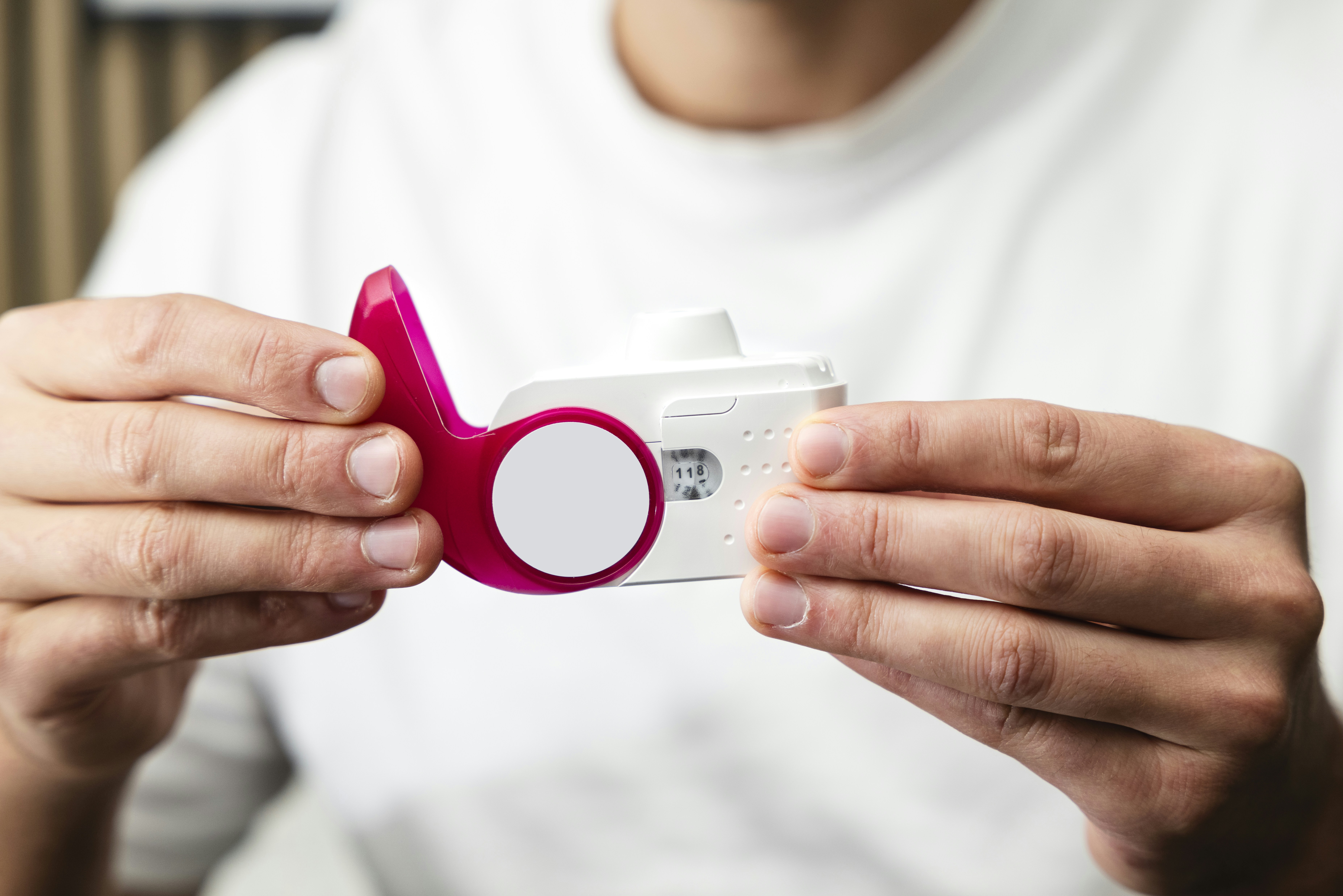 A person holding a small device in their hands