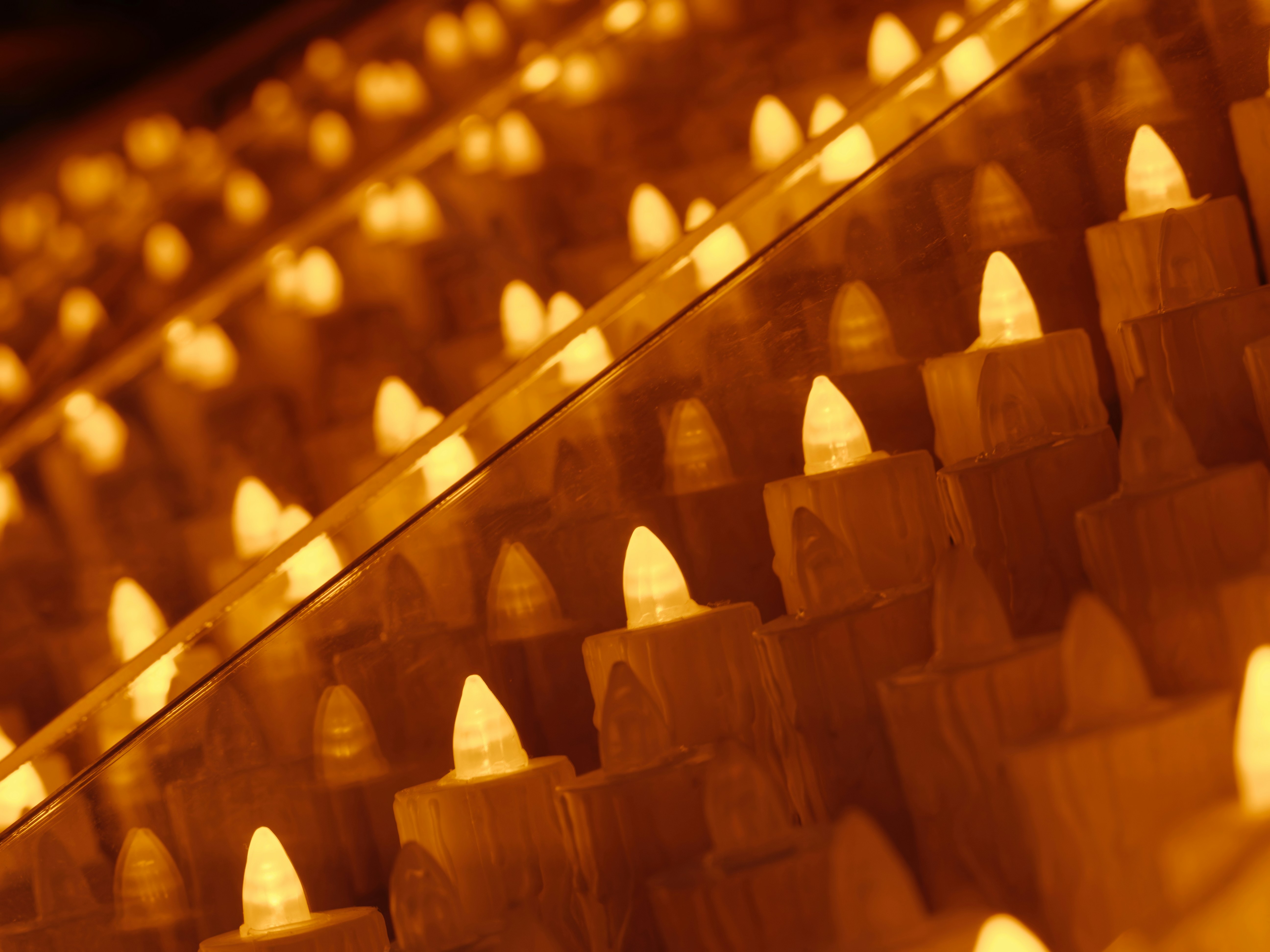 A row of lit candles sitting next to each other
