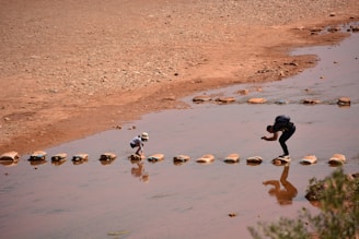 A couple of people that are standing in the water