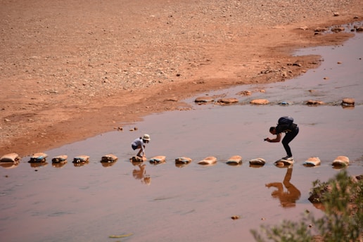 A couple of people that are standing in the water