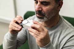 A man sitting in a green chair holding a camera