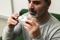 A man sitting in a green chair holding a camera
