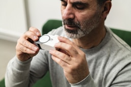 A man sitting in a green chair holding a camera