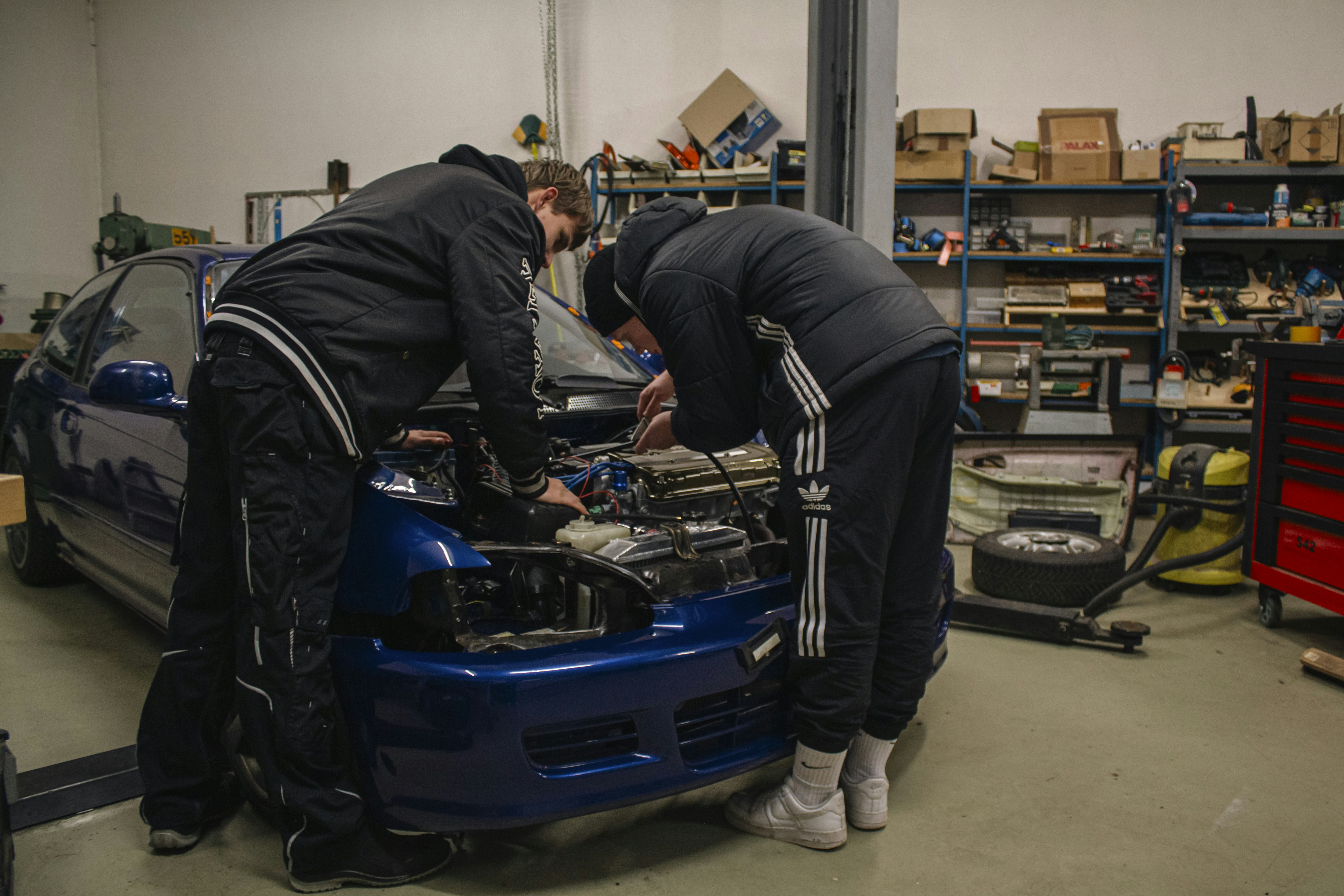 Technician inspecting the battery pack of an electric vehicle in a workshop