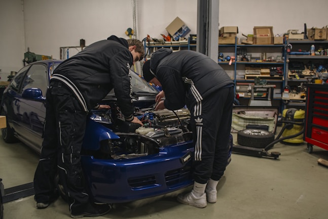 Two men working on a car in a garage