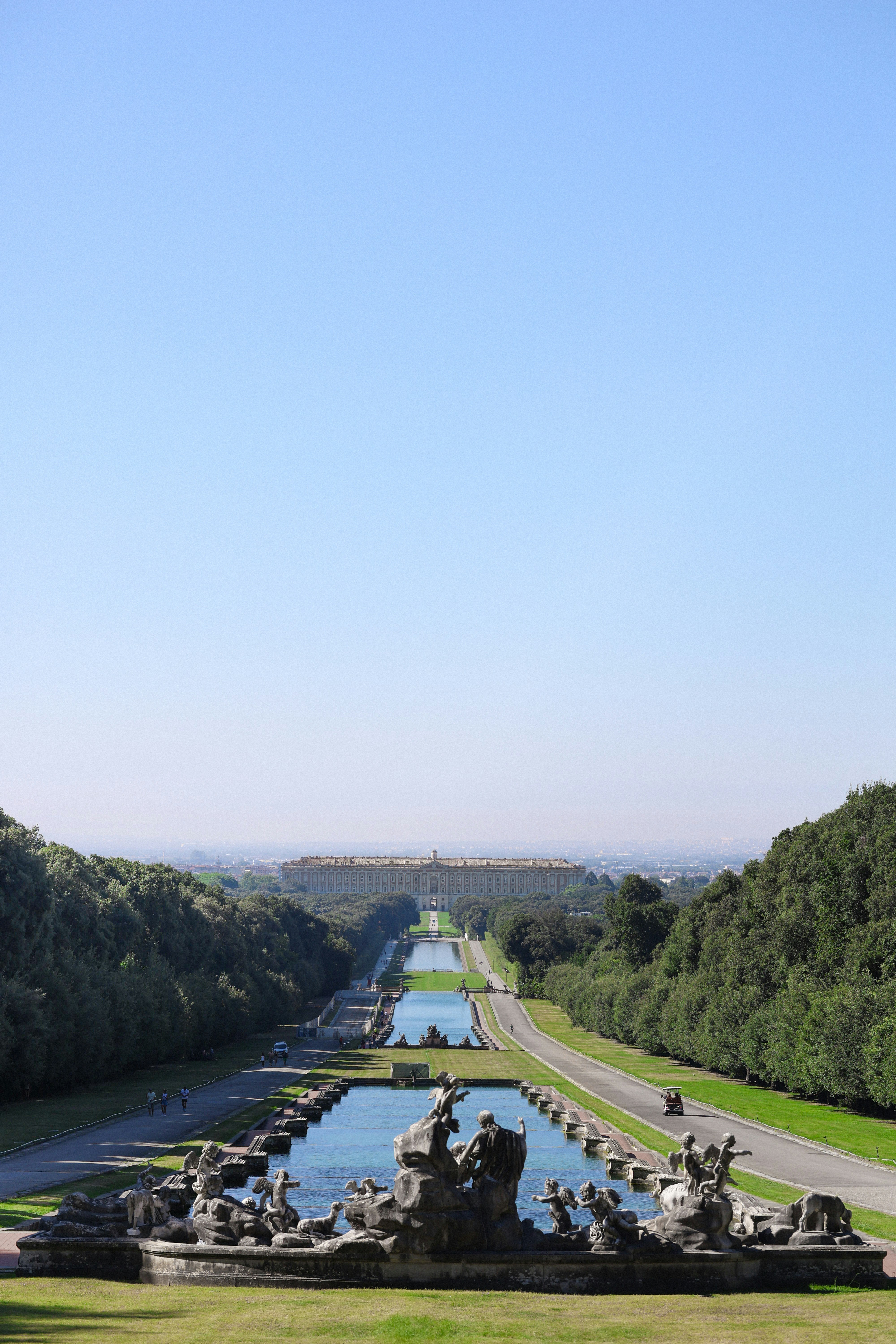 A view of a long road with a fountain in the middle of it