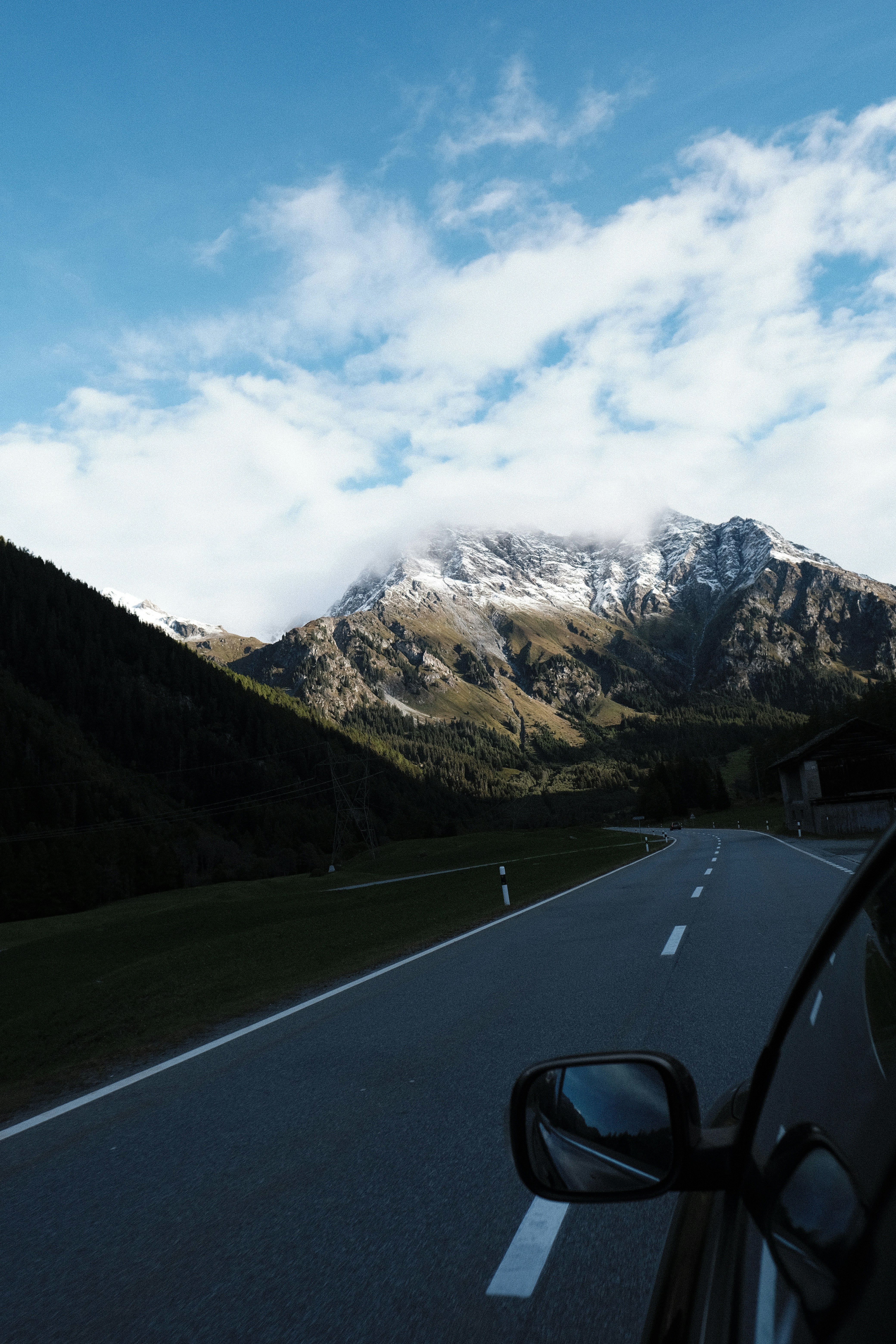 A car driving down a road with mountains in the background
