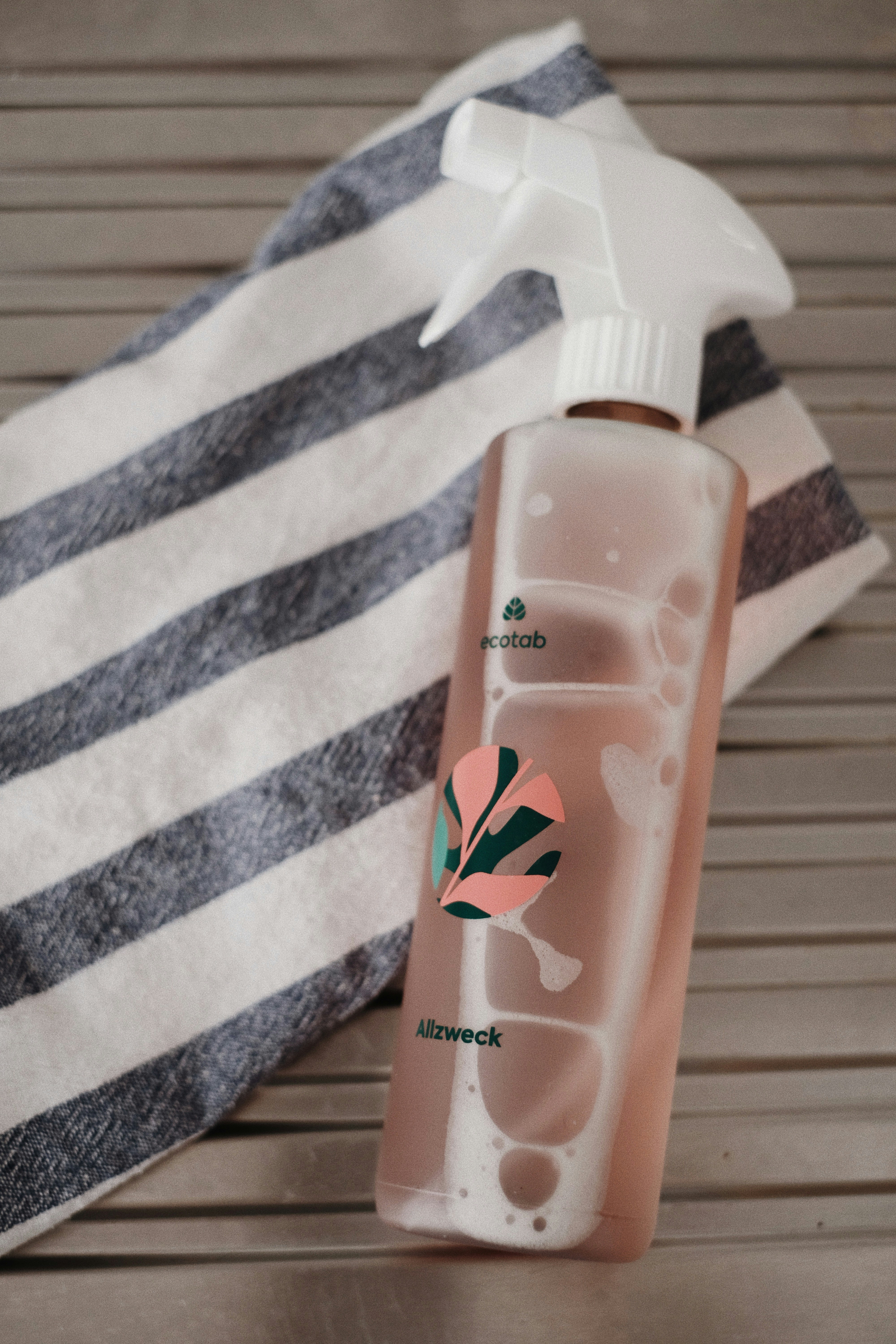 A bottle of hand sanitizer next to a towel