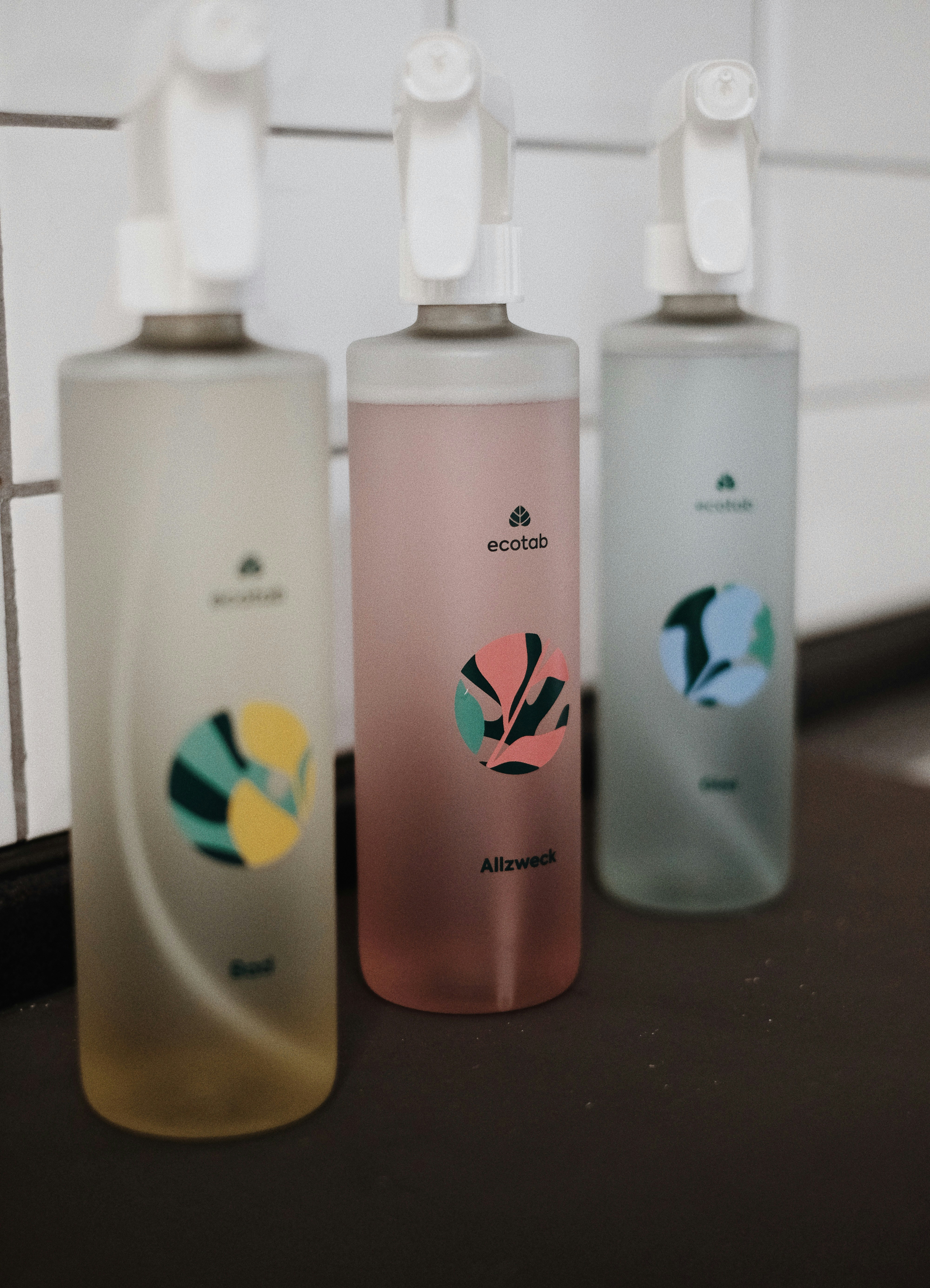 Three bottles of hand sanitizer sitting on a counter