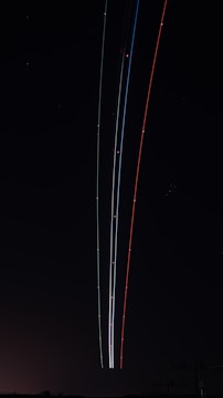 A long line of airplanes flying in the night sky