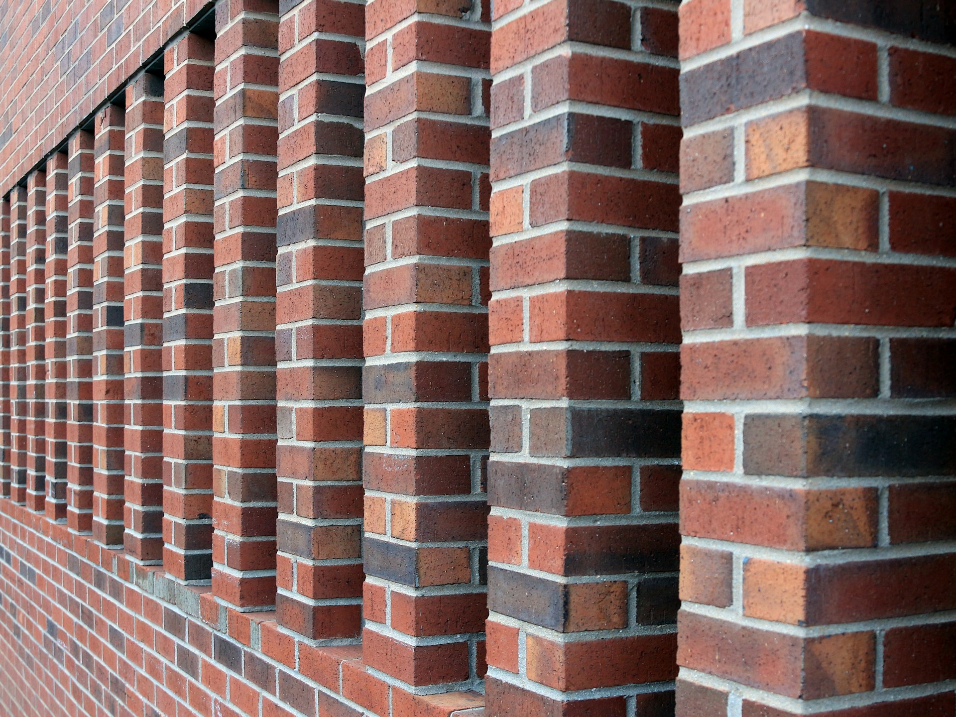 A red brick wall with a row of windows