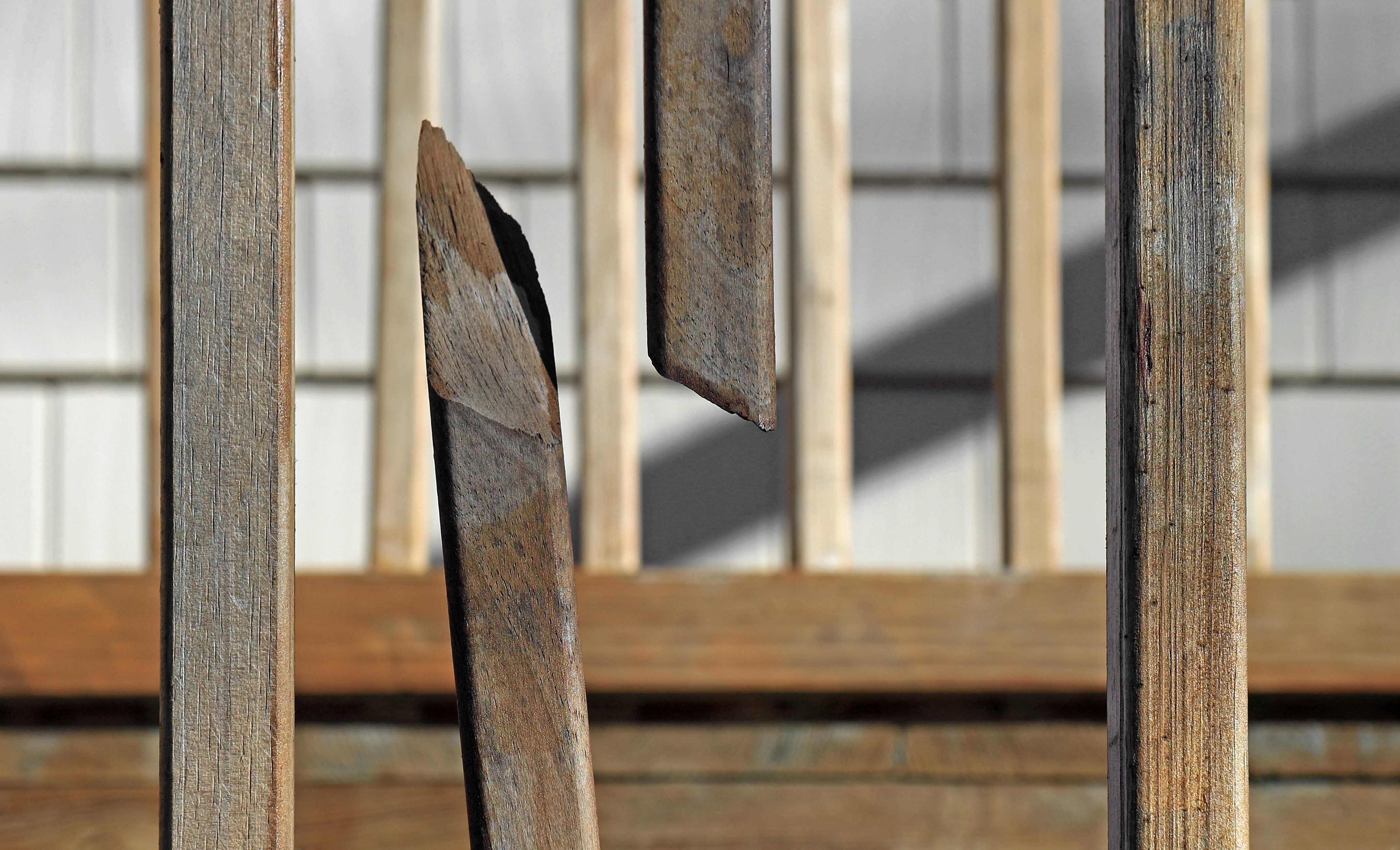 A close up of a piece of wood with a building in the background