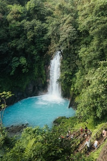 A group of people standing in front of a waterfall