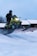 A person riding a snowmobile in the snow