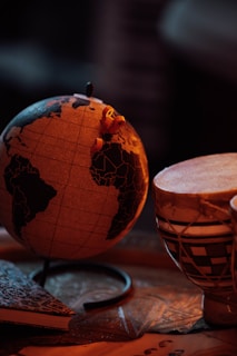 A wooden table topped with two cups and a globe