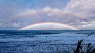 A double rainbow is seen over the ocean