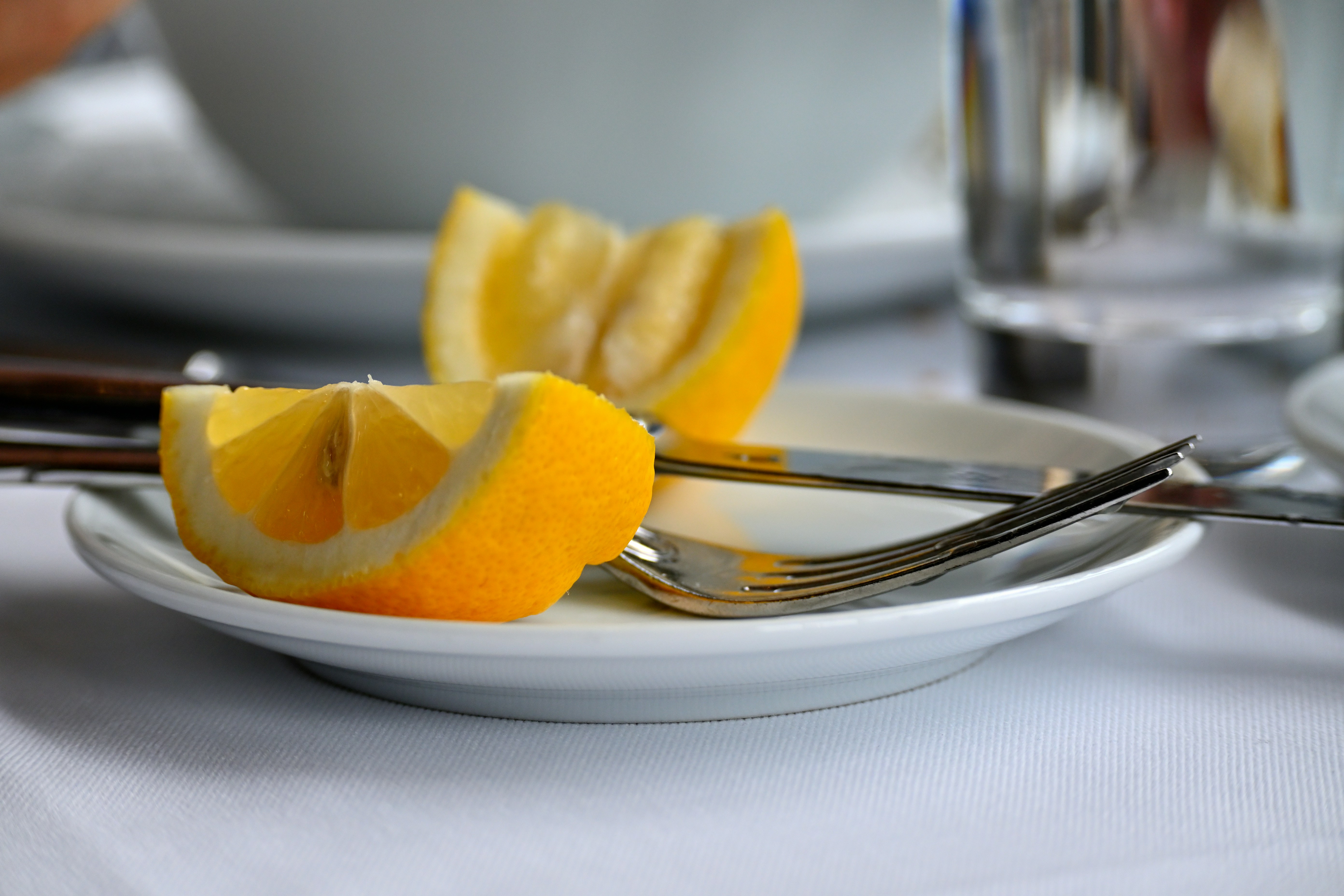 A white plate topped with sliced lemons and a fork