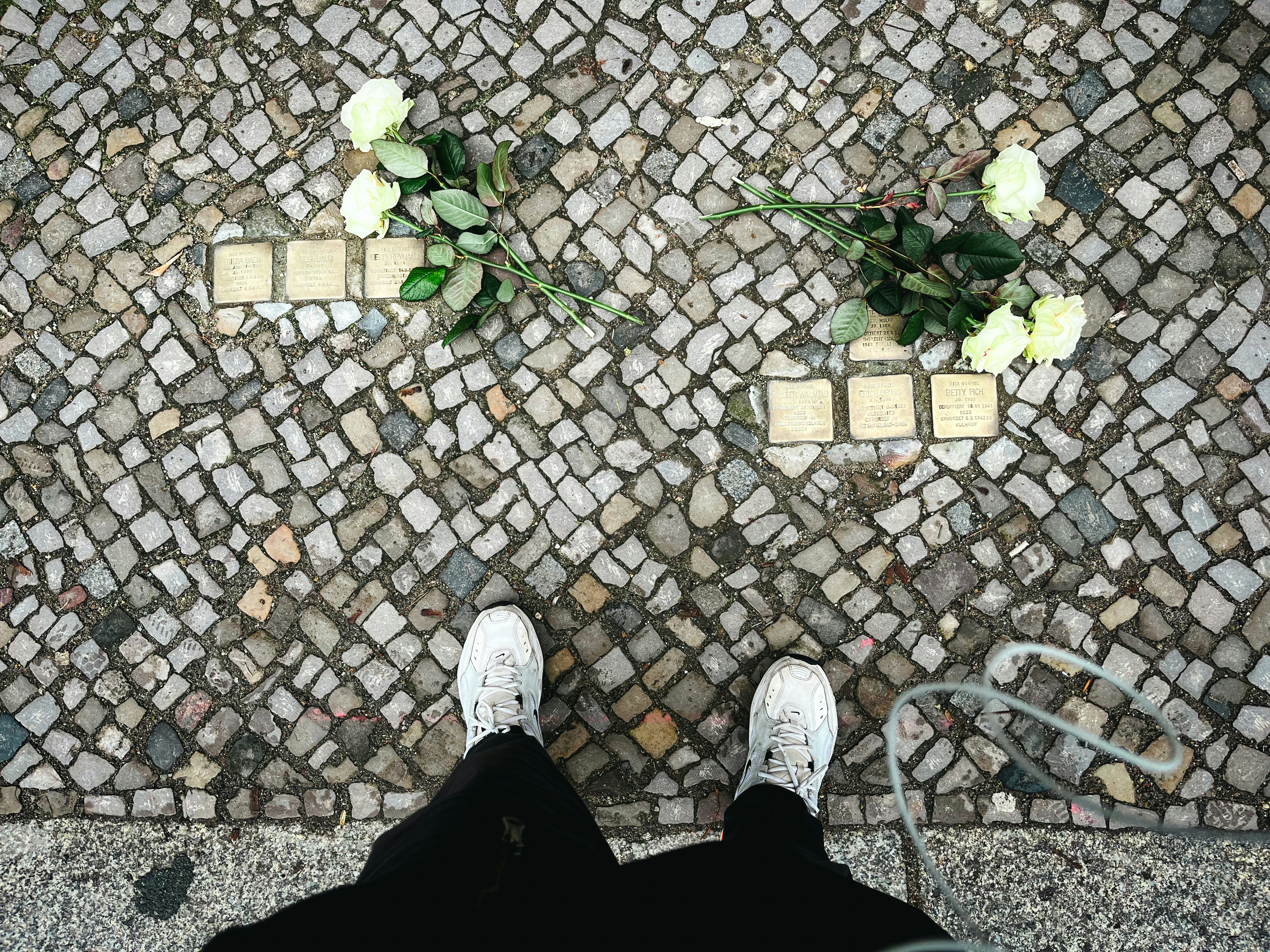 A person standing on a sidewalk with their feet up