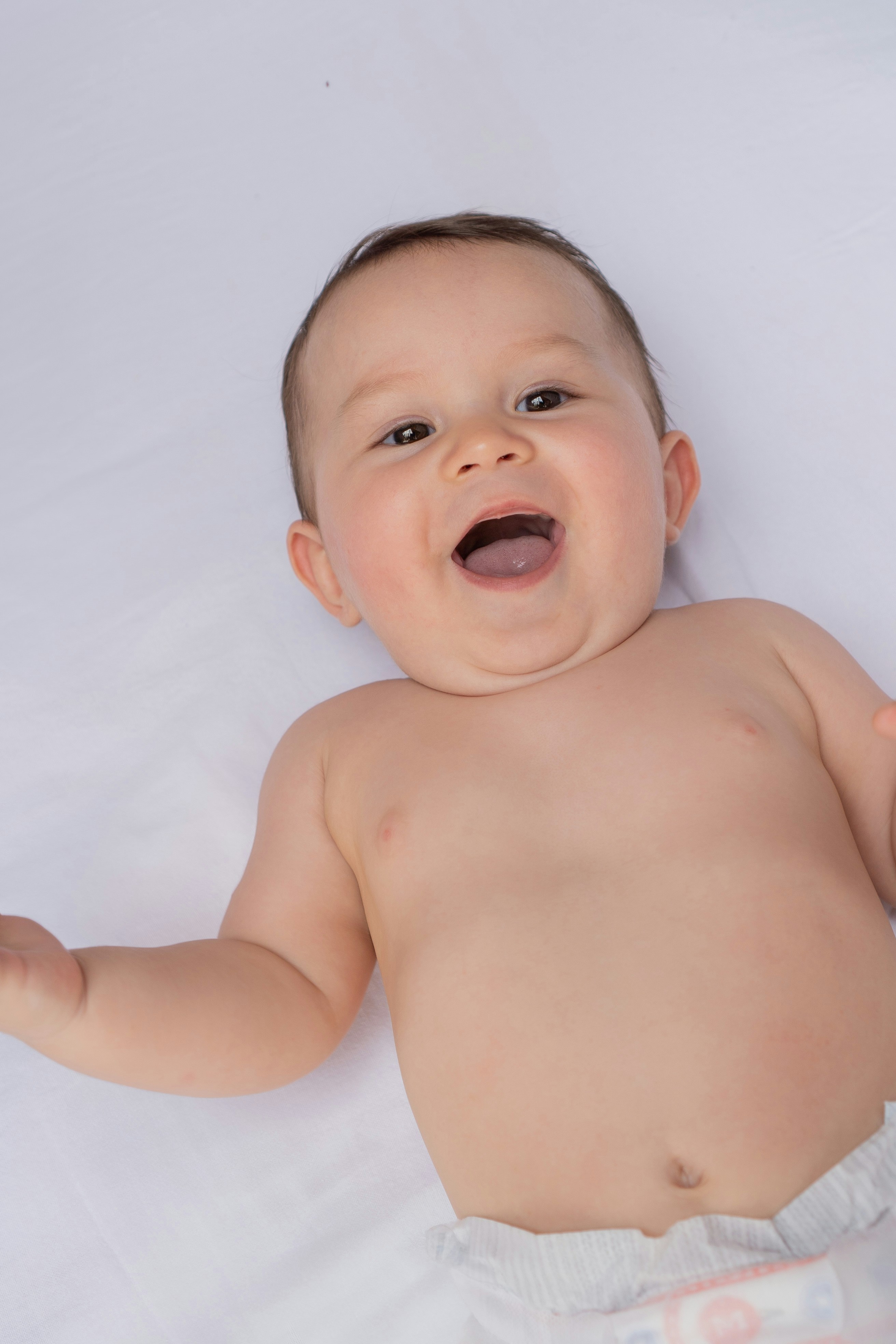 En bebis ligger på ett vitt lakan