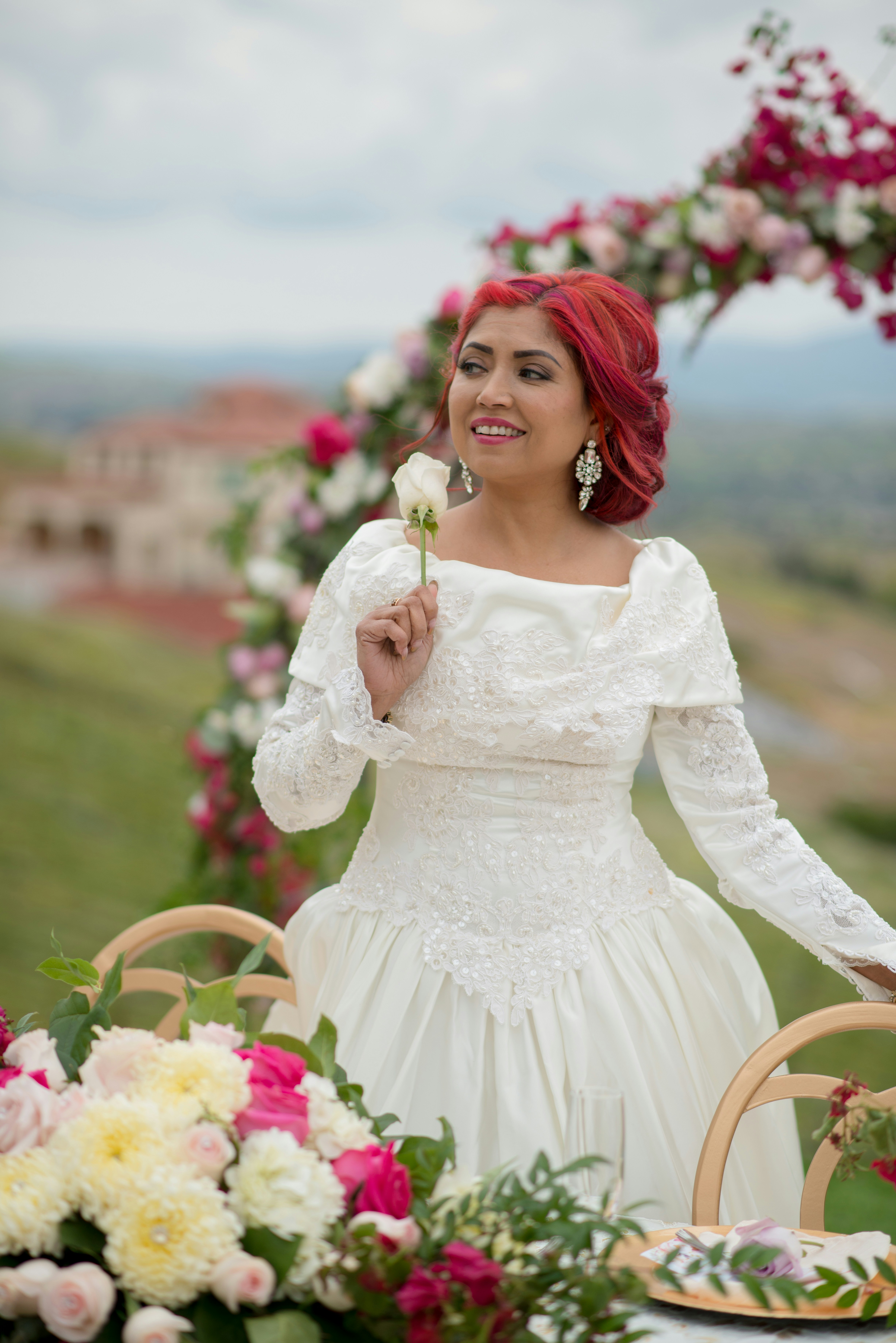A woman in a white dress holding a flower