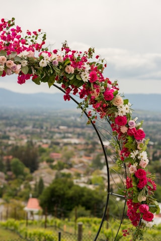 A wedding arch decorated with pink and white flowers