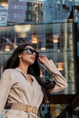 A woman in a tan coat and sunglasses