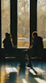 Two people sitting in chairs in front of large windows