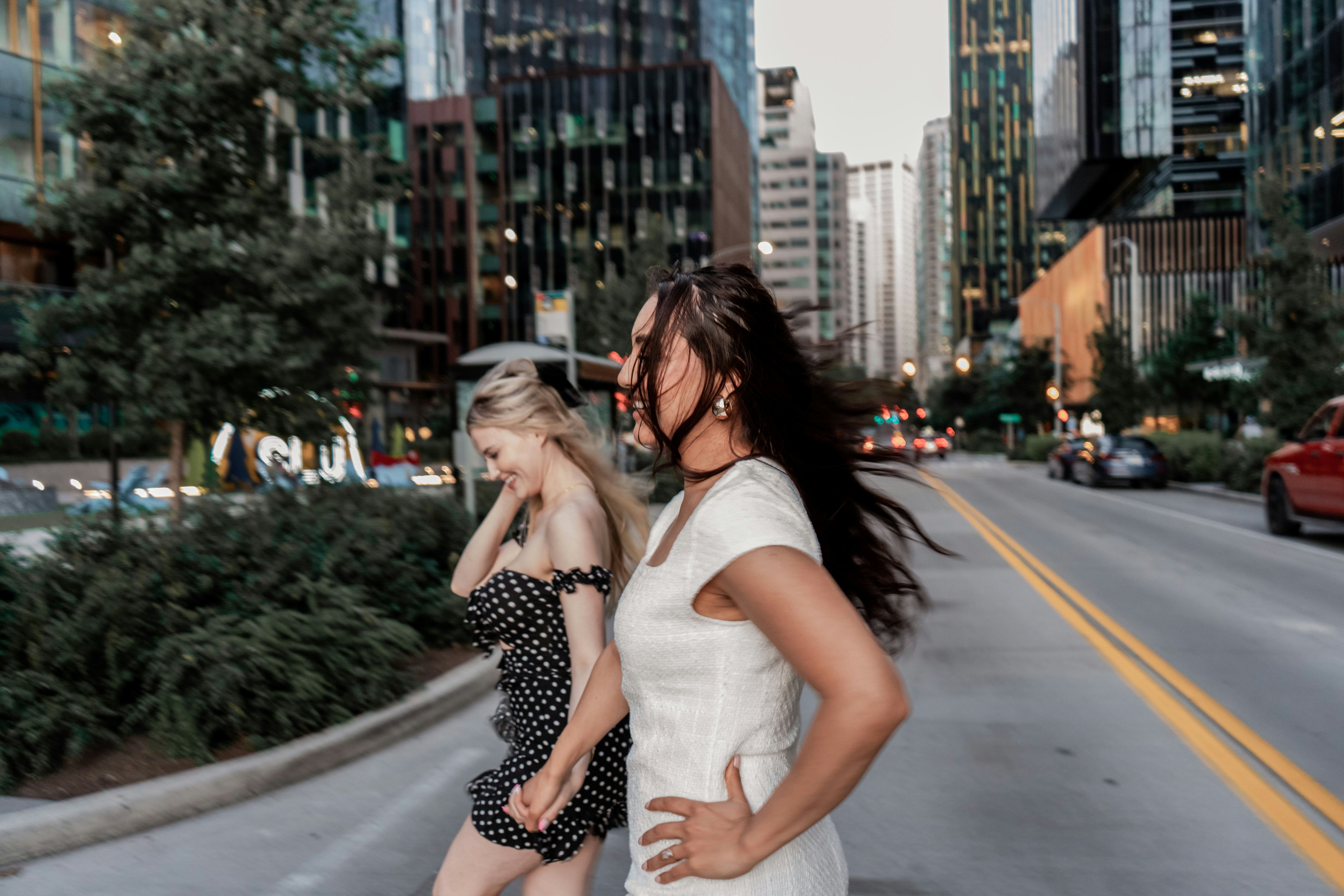 A couple of women standing on the side of a road