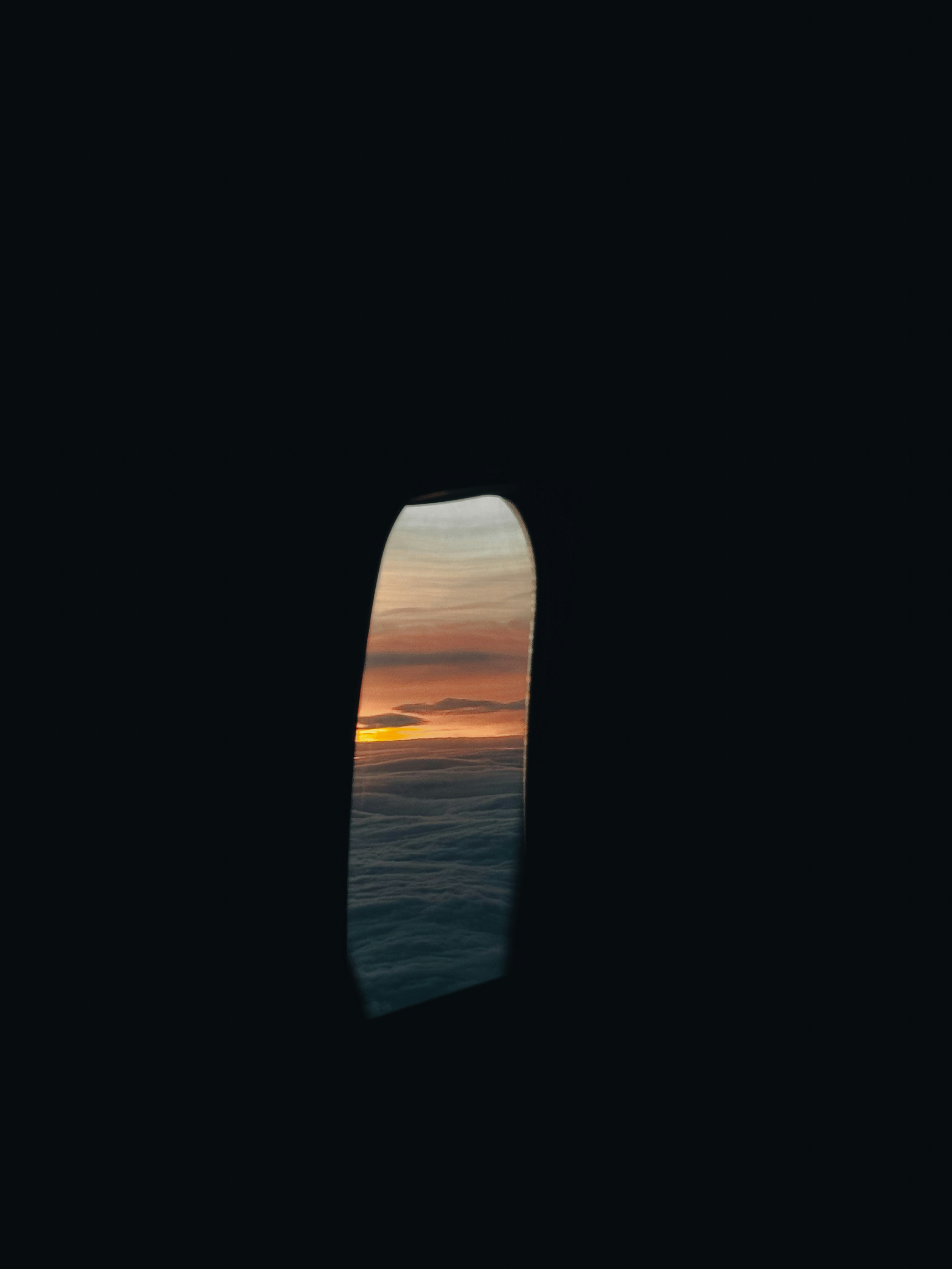An airplane window with a view of the ocean
