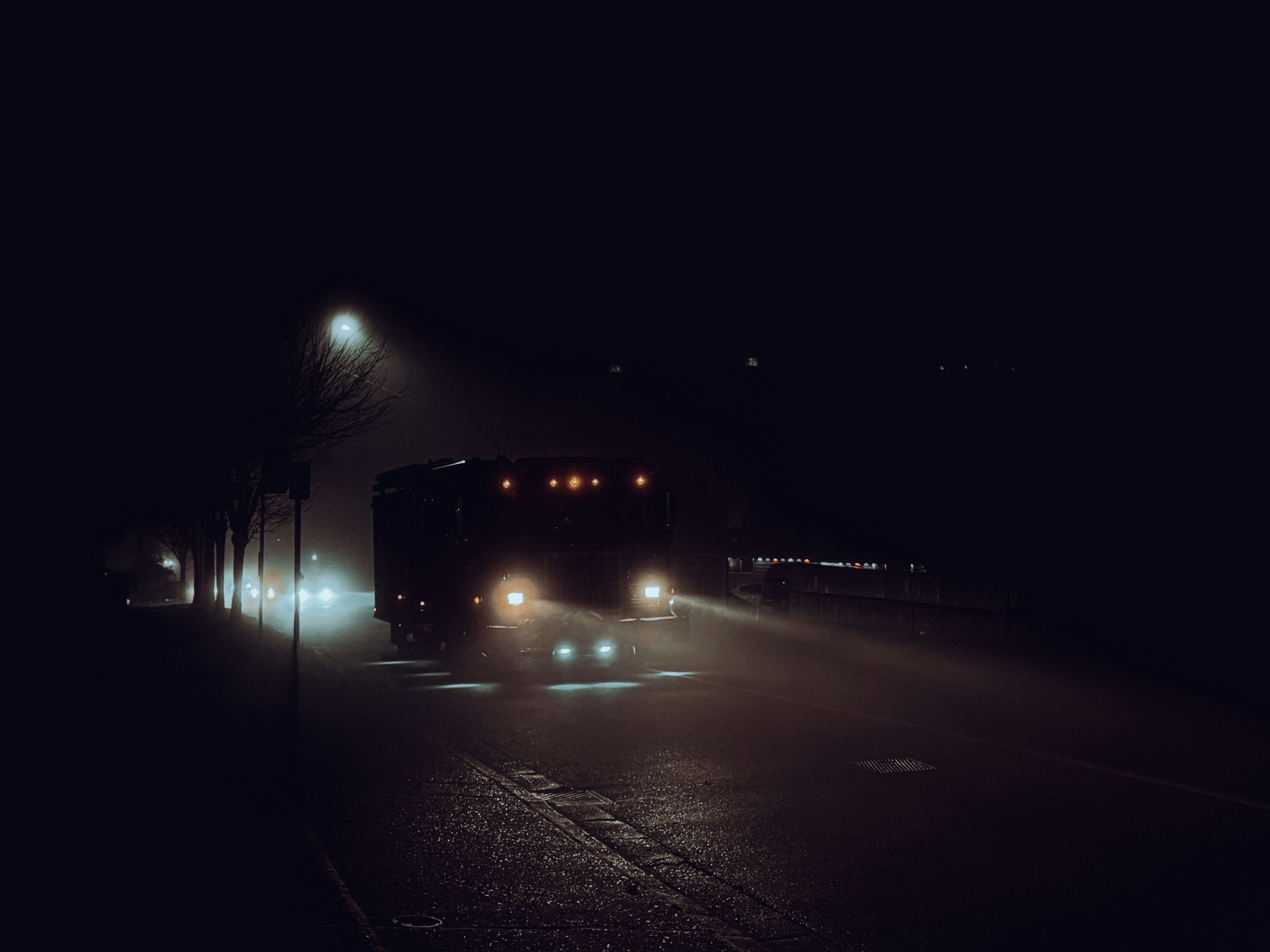 A truck driving down a street at night