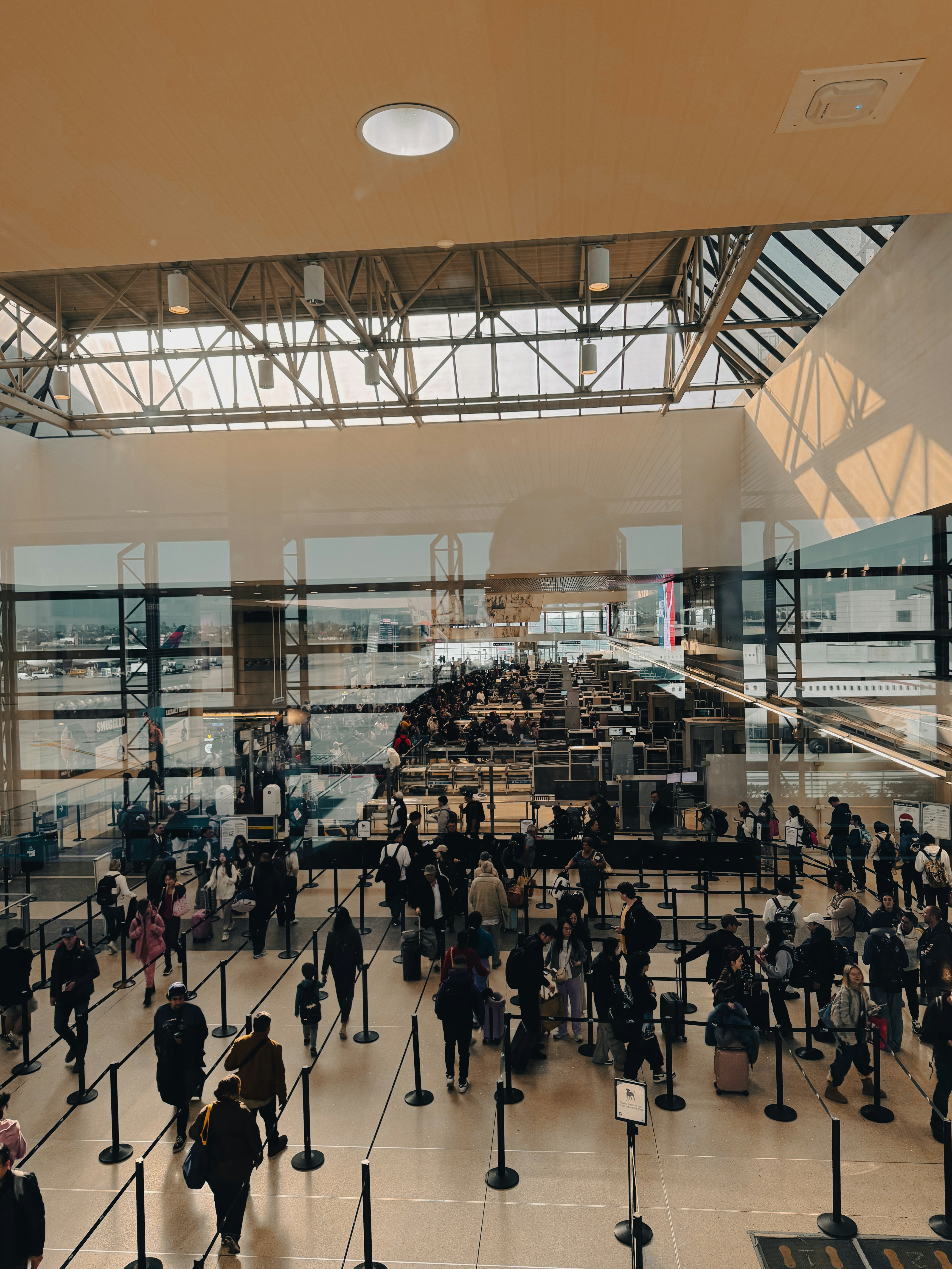 A large group of people walking around an airport.