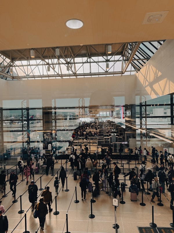 Travelers queue through a crowded TSA checkpoint as flight delays ripple nationwide