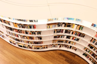 A curved book shelf filled with lots of books